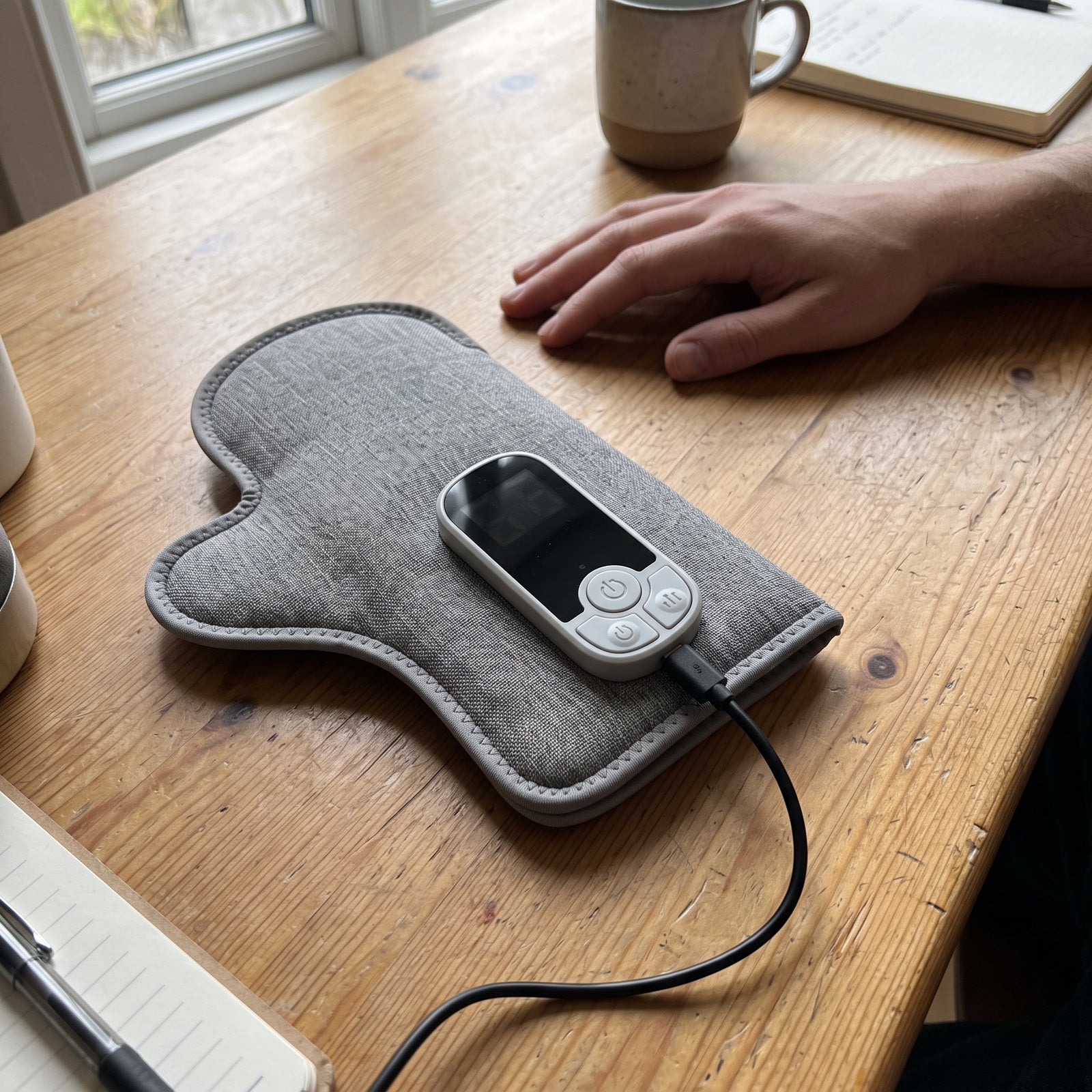 Powered-off Palmhaven charging through USB-C on a wooden table